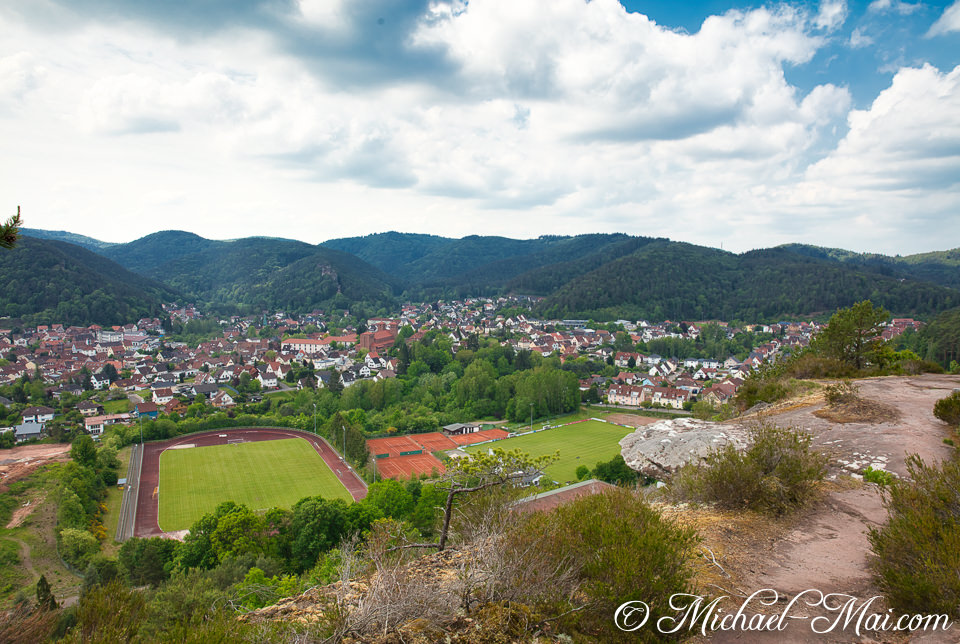 Overlooking a scenic valley, a vibrant town unfolds with stadiums and distant hills. | Hauenstein, Germany
