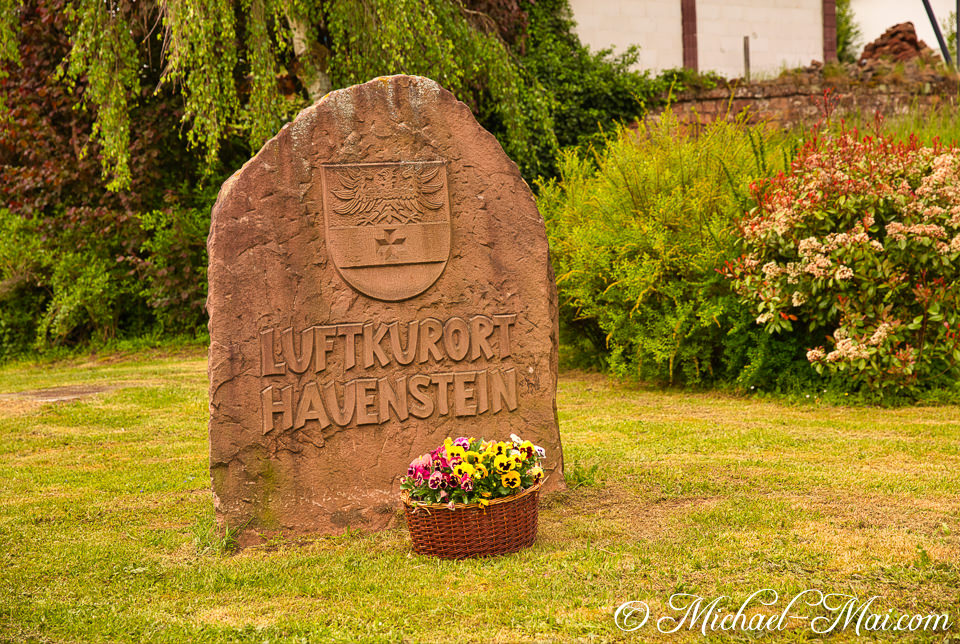 Carved stone monument announces Hauenstein, a climatic health resort, with bright pansies below. | Hauenstein, Germany