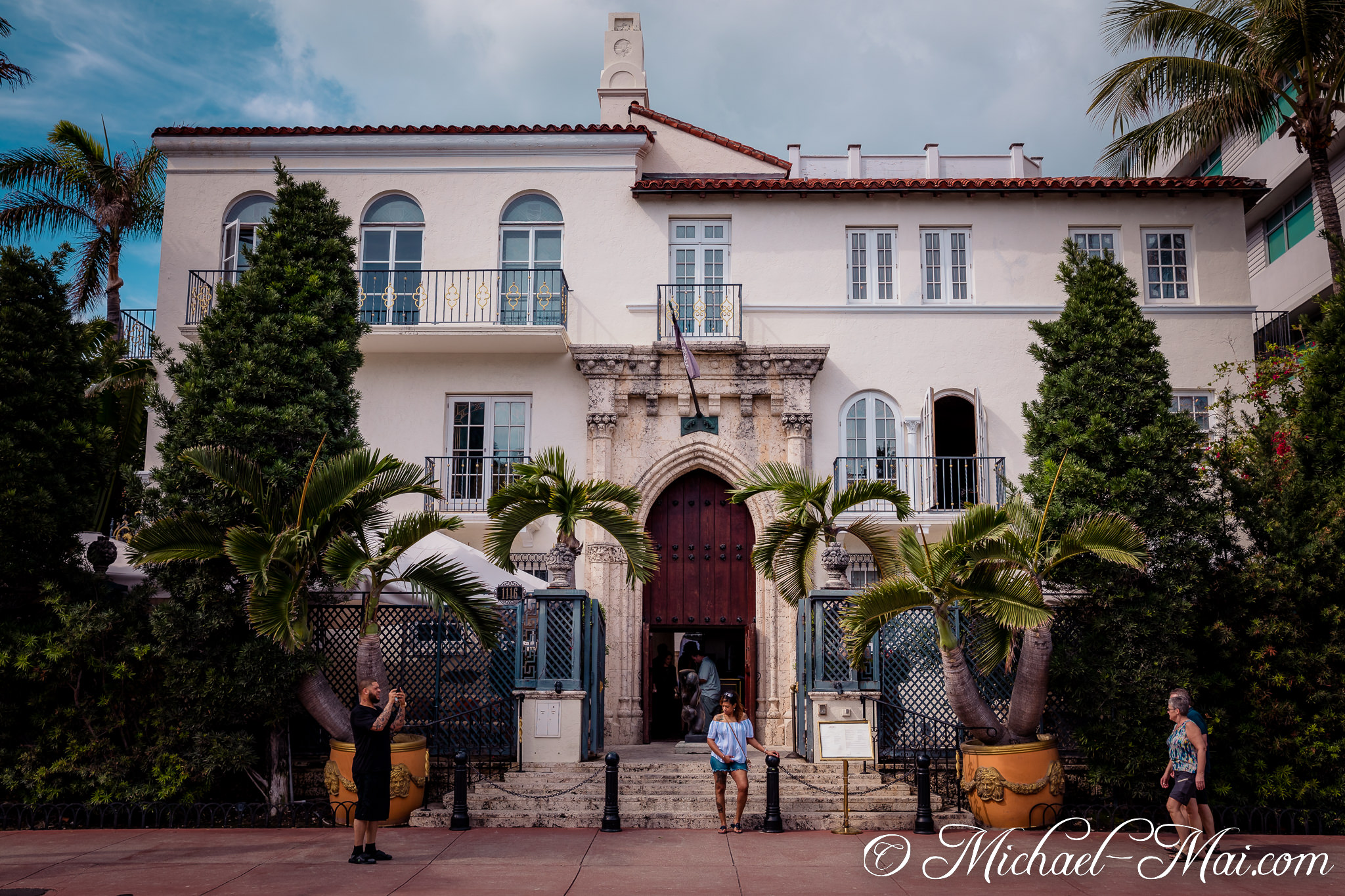 Visitors capture the iconic beauty of a magnificent Mediterranean-style mansion. | Miami Beach, Florida, United States