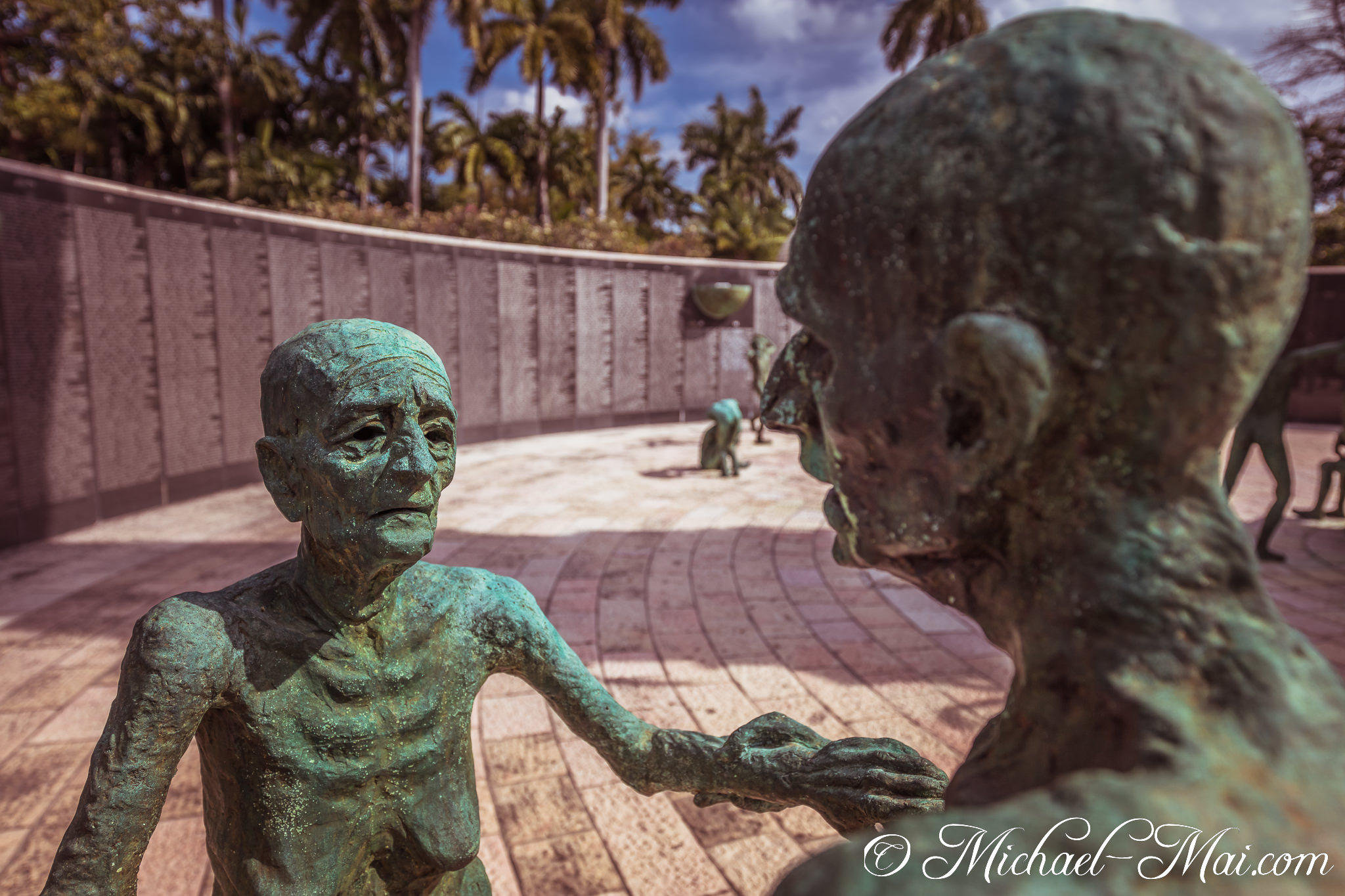 Gaunt bronze figures meet with clasped hands, conveying shared grief. | Miami Beach, Florida, United States