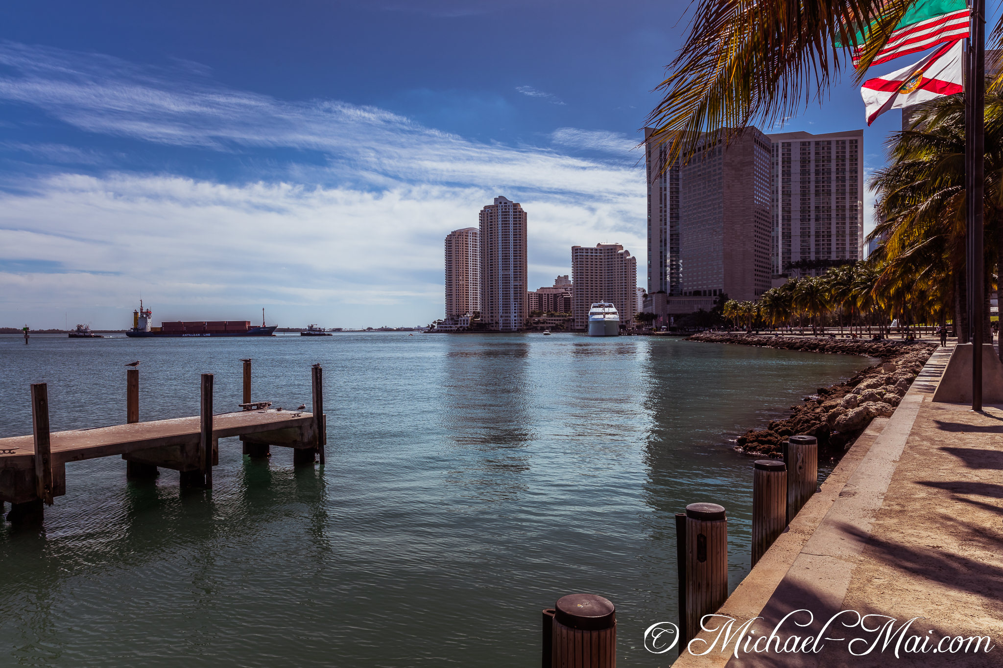 Miami's bay buzzes with maritime activity, framed by a quiet pier and city skyline. | Miami, Florida, United States