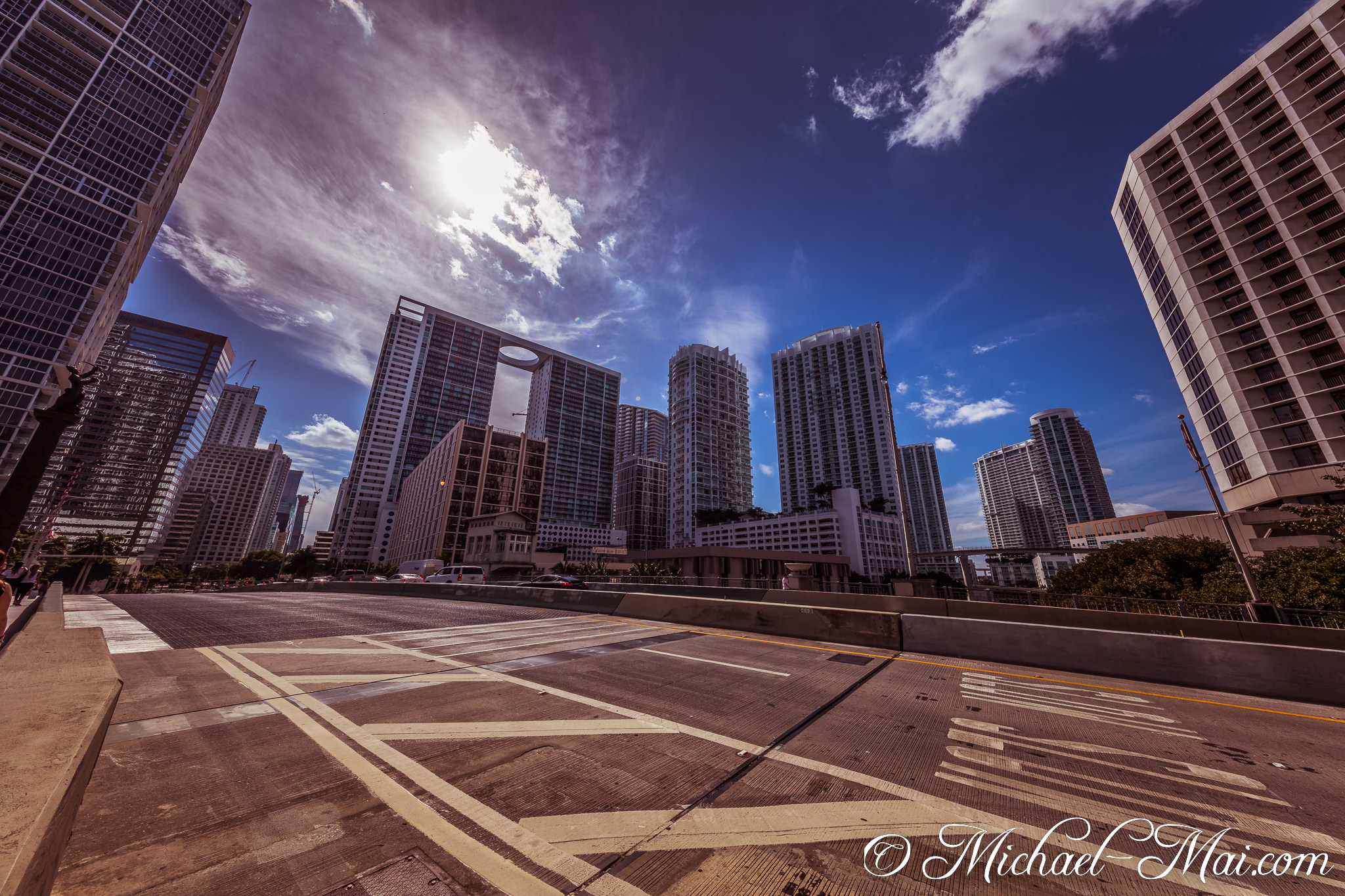Dramatic sunburst over urban skyscrapers and a busy street, highlighting Miami's dynamic architecture. | Miami, Florida, United States