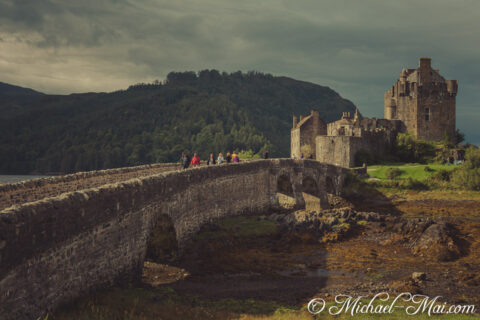 Dramatic light illuminates an iconic Scottish castle and its connecting stone bridge. | Eilean Donan Castle, Scotland