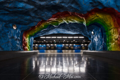 Painted cavern walls create a vibrant art installation above a speeding subway.