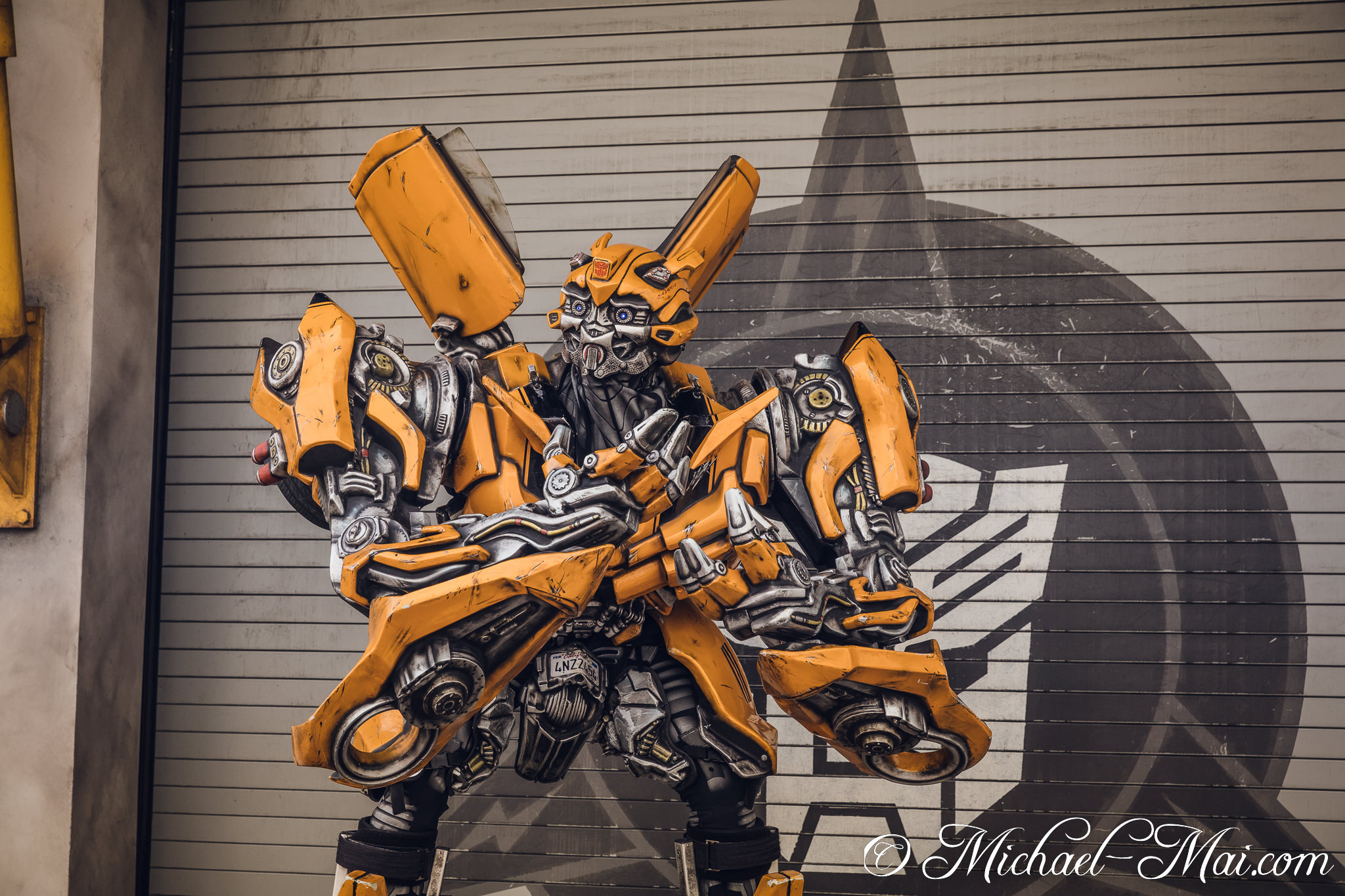 Detailed Bumblebee robot stands ready against a wall marked with the Decepticon symbol. | Orlando, Florida, United States