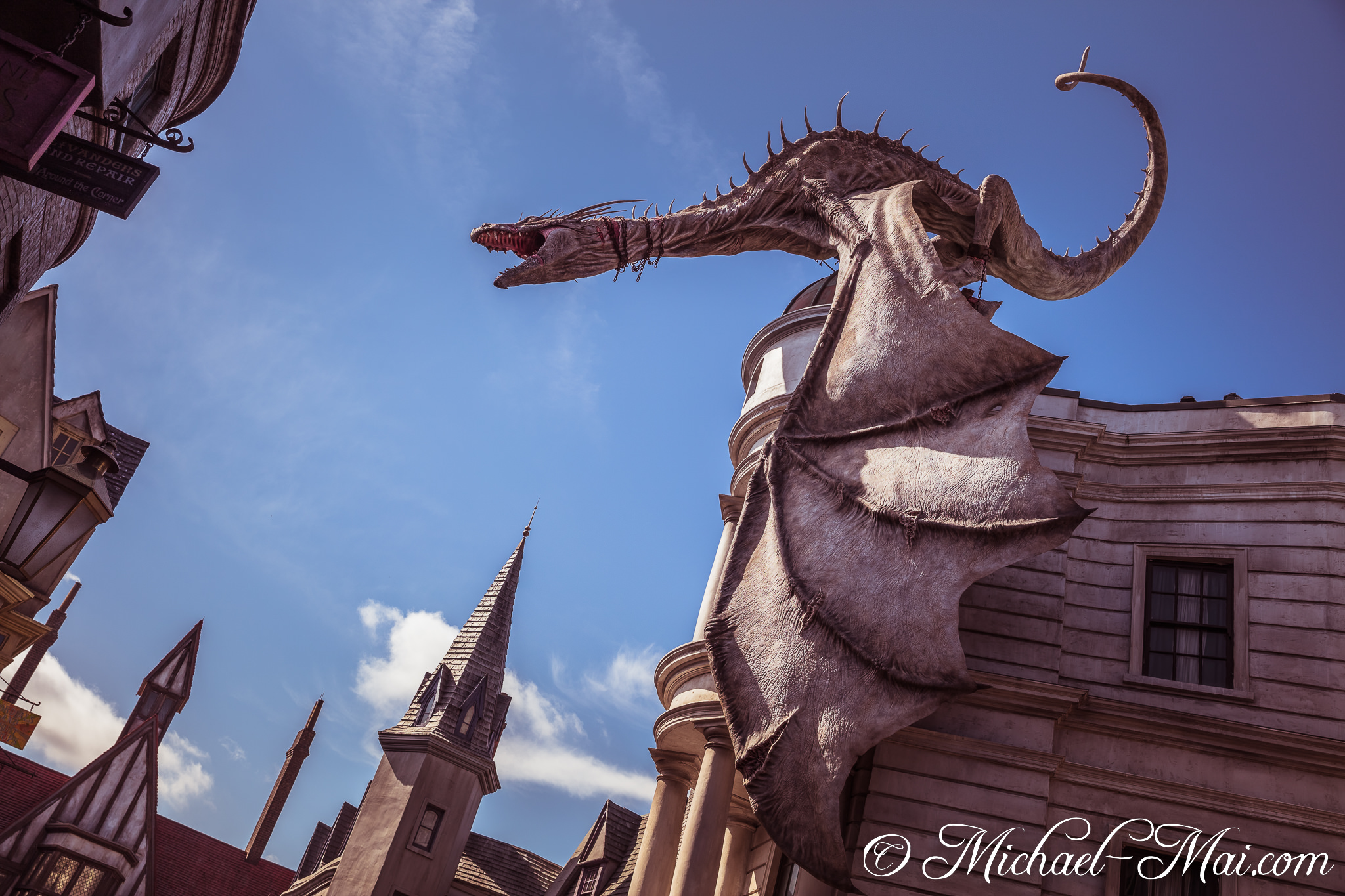 Ferocious Gringotts dragon, wings unfurled, dominates the azure sky and magical architecture. | Orlando, Florida, United States