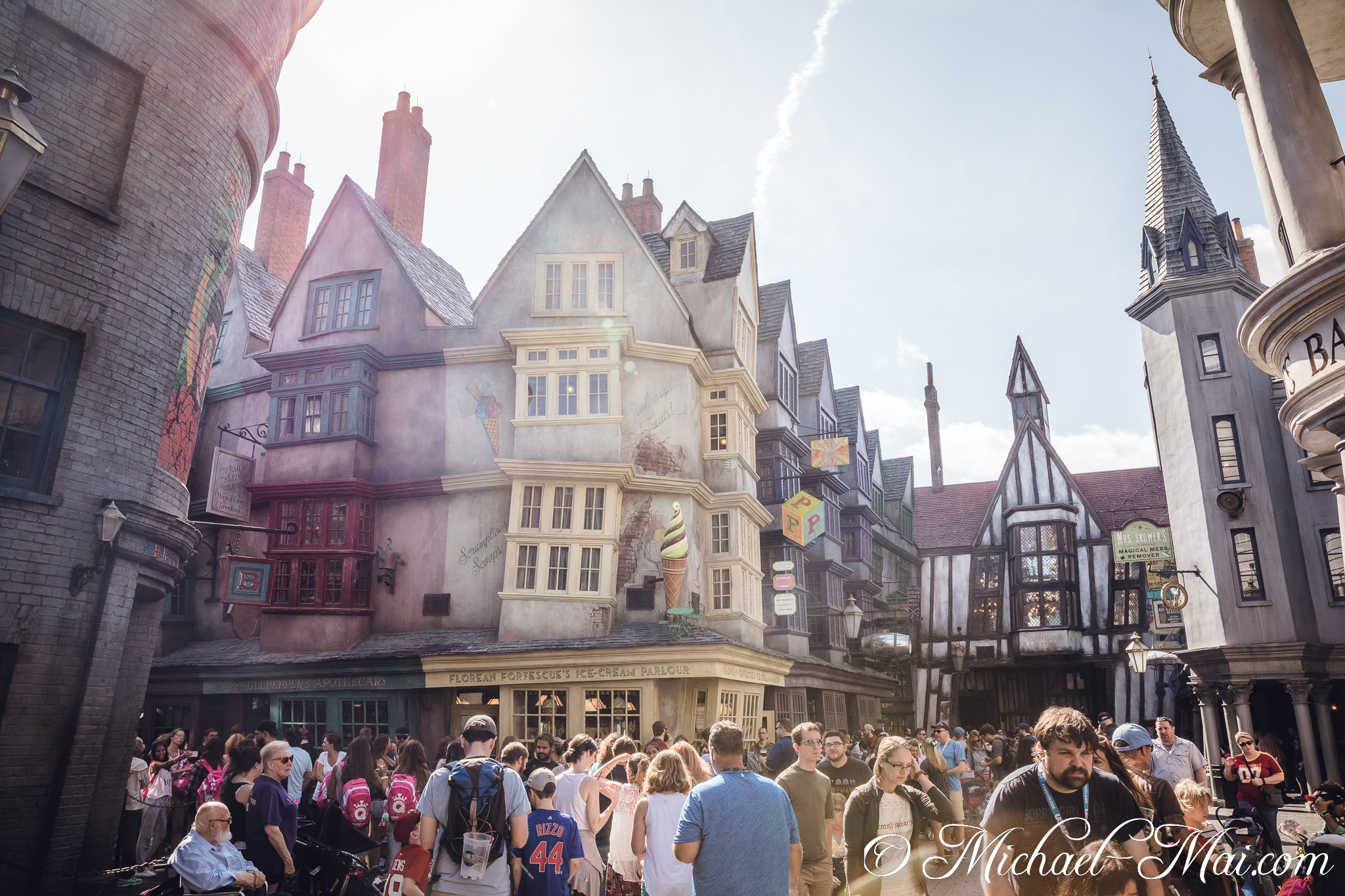 Eager visitors explore the enchanting, irregularly shaped buildings lining a vibrant wizarding street. | Orlando, Florida, United States