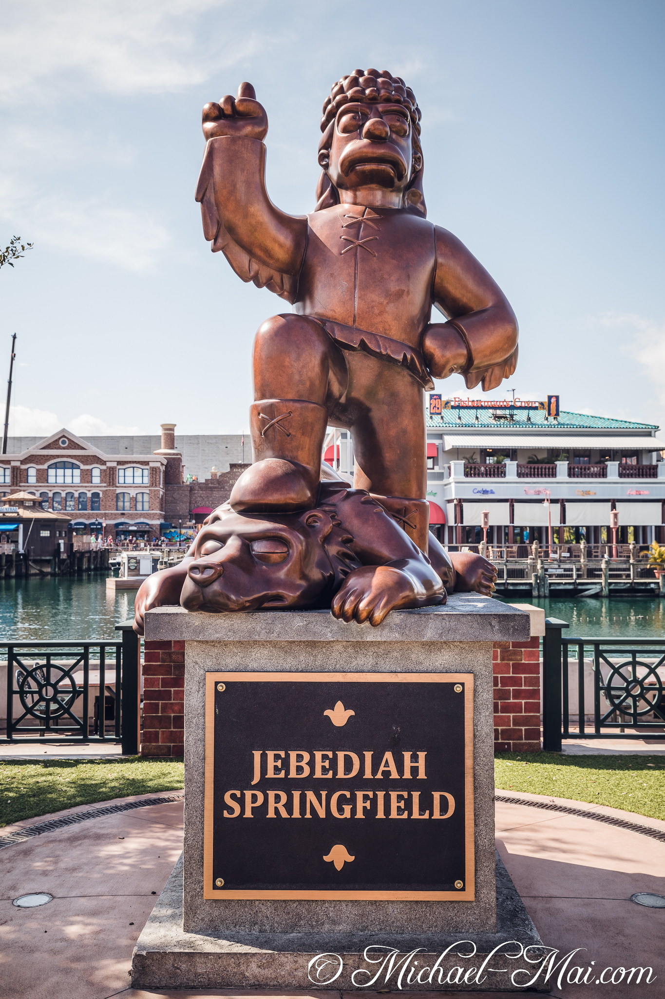 Bronze Jebediah Springfield statue triumphantly stands over a defeated bear near the water. | Orlando, Florida, United States