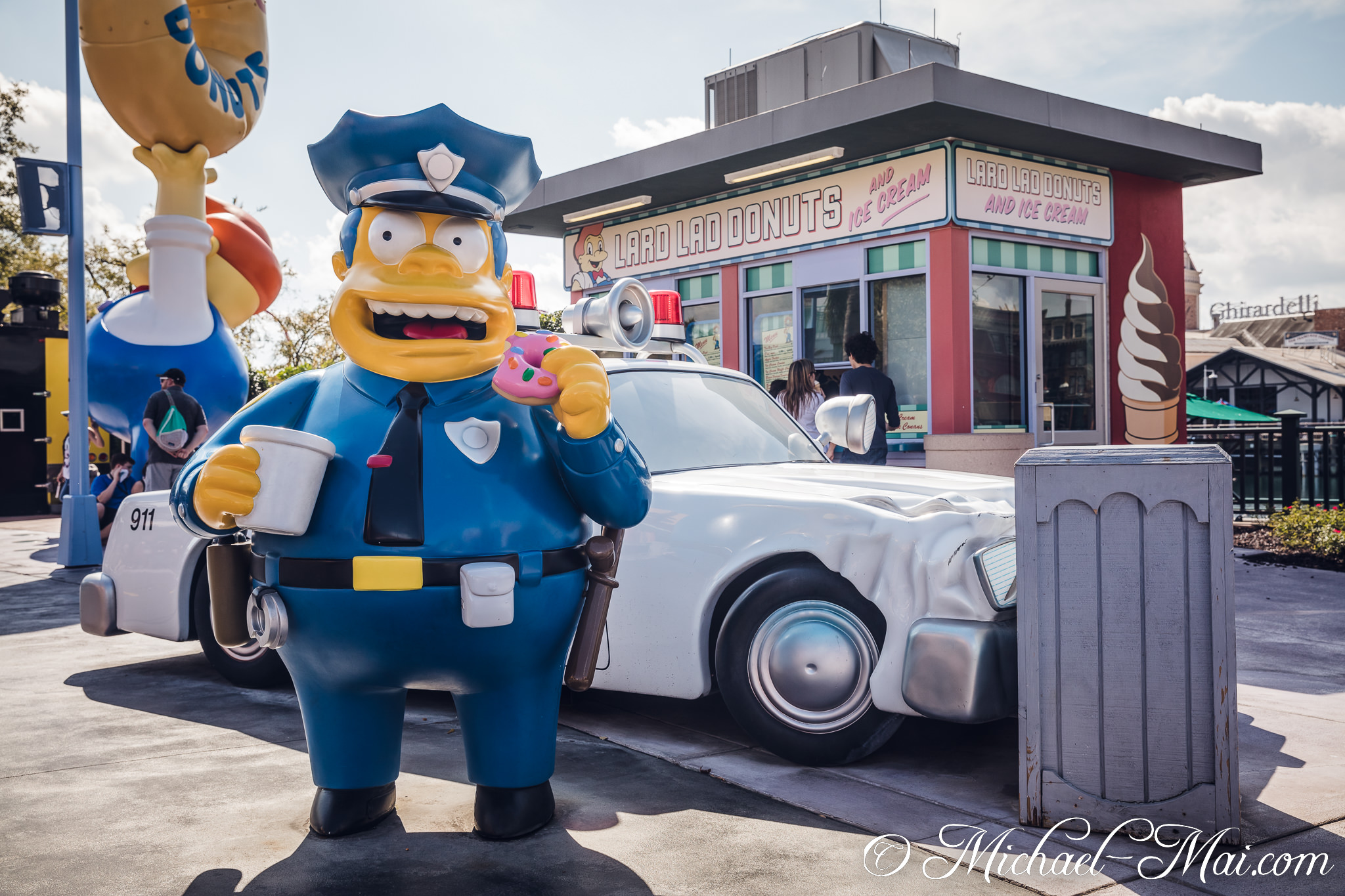A cheerful Chief Wiggum enjoys a donut and coffee outside Lard Lad Donuts. | Orlando, Florida, United States