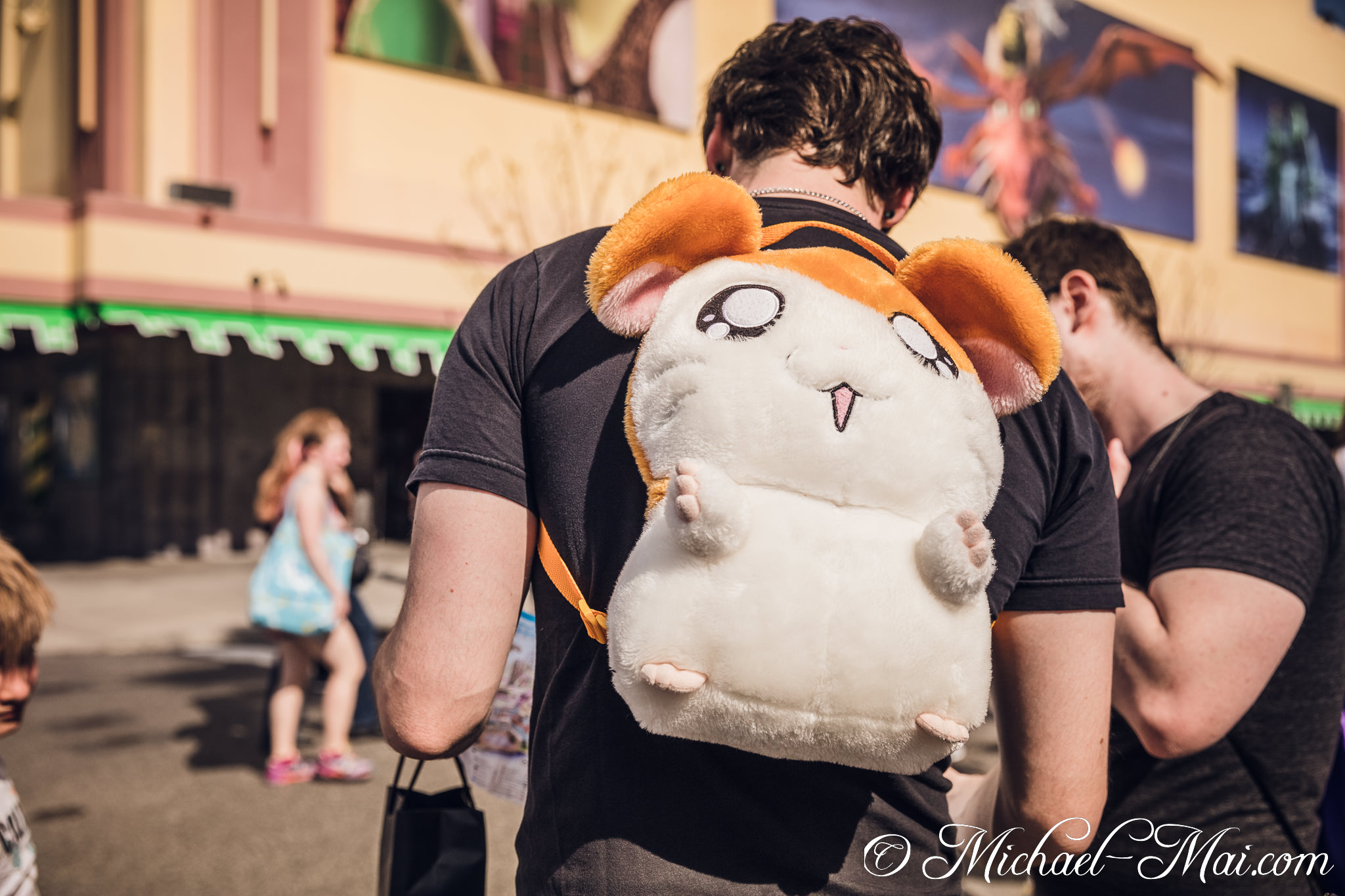 A person sports a whimsical, oversized hamster backpack, adding fun to a sunny day. | Orlando, Florida, United States