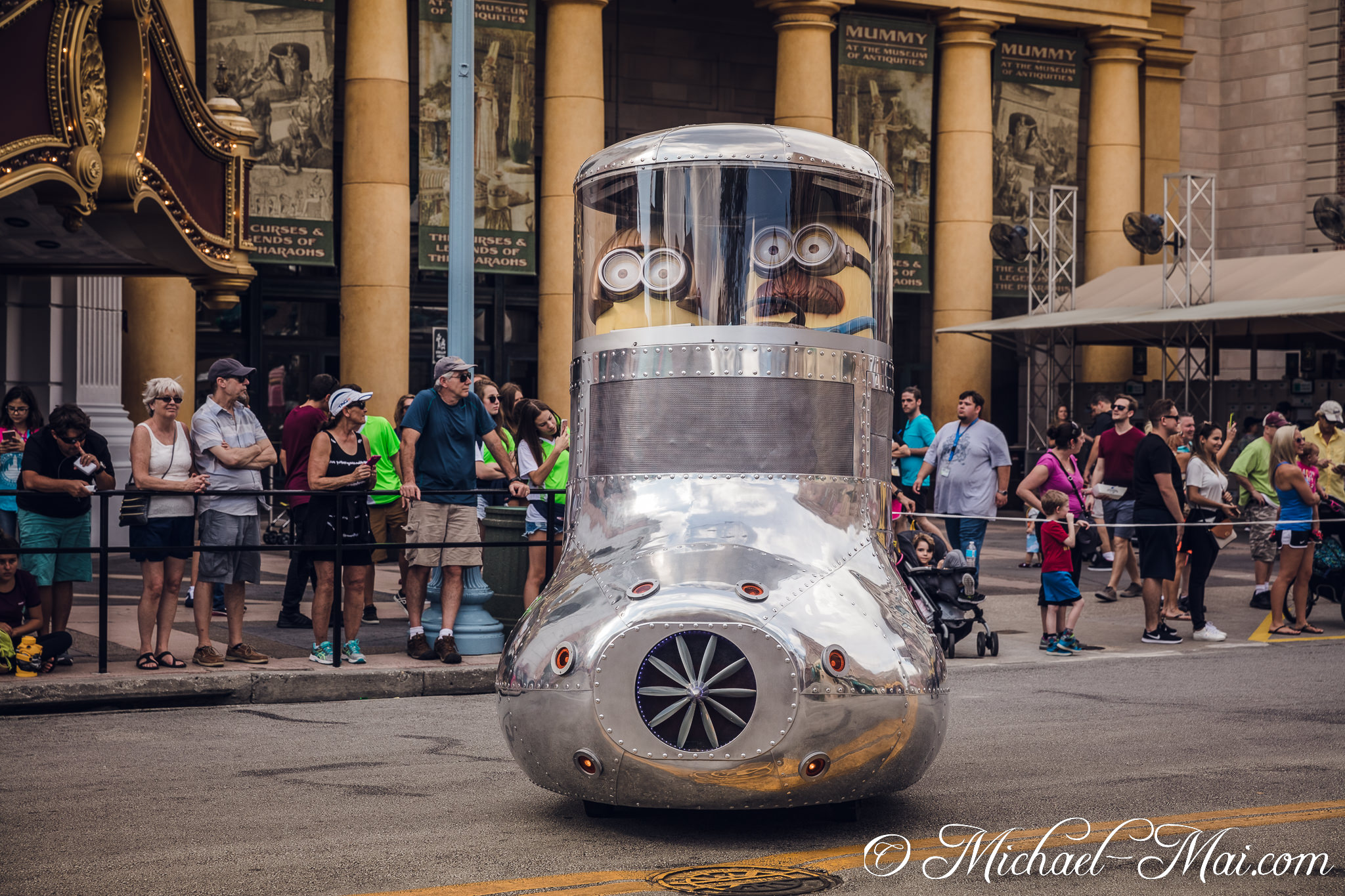 From a shiny, bubble-topped vehicle, two Minions observe the theme park crowd. | Orlando, Florida, United States