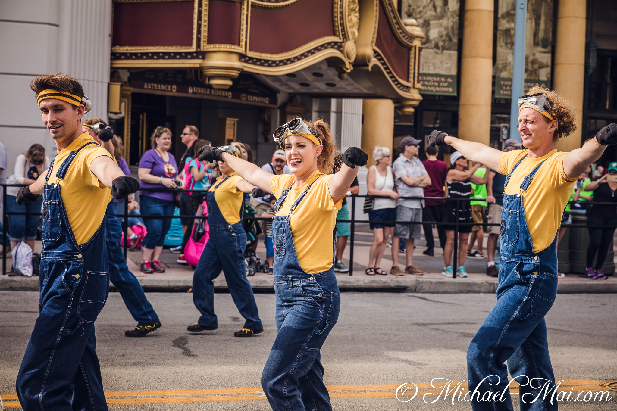 Joyful Minion performers beam, extending arms during a lively street parade. | Orlando, Florida, United States