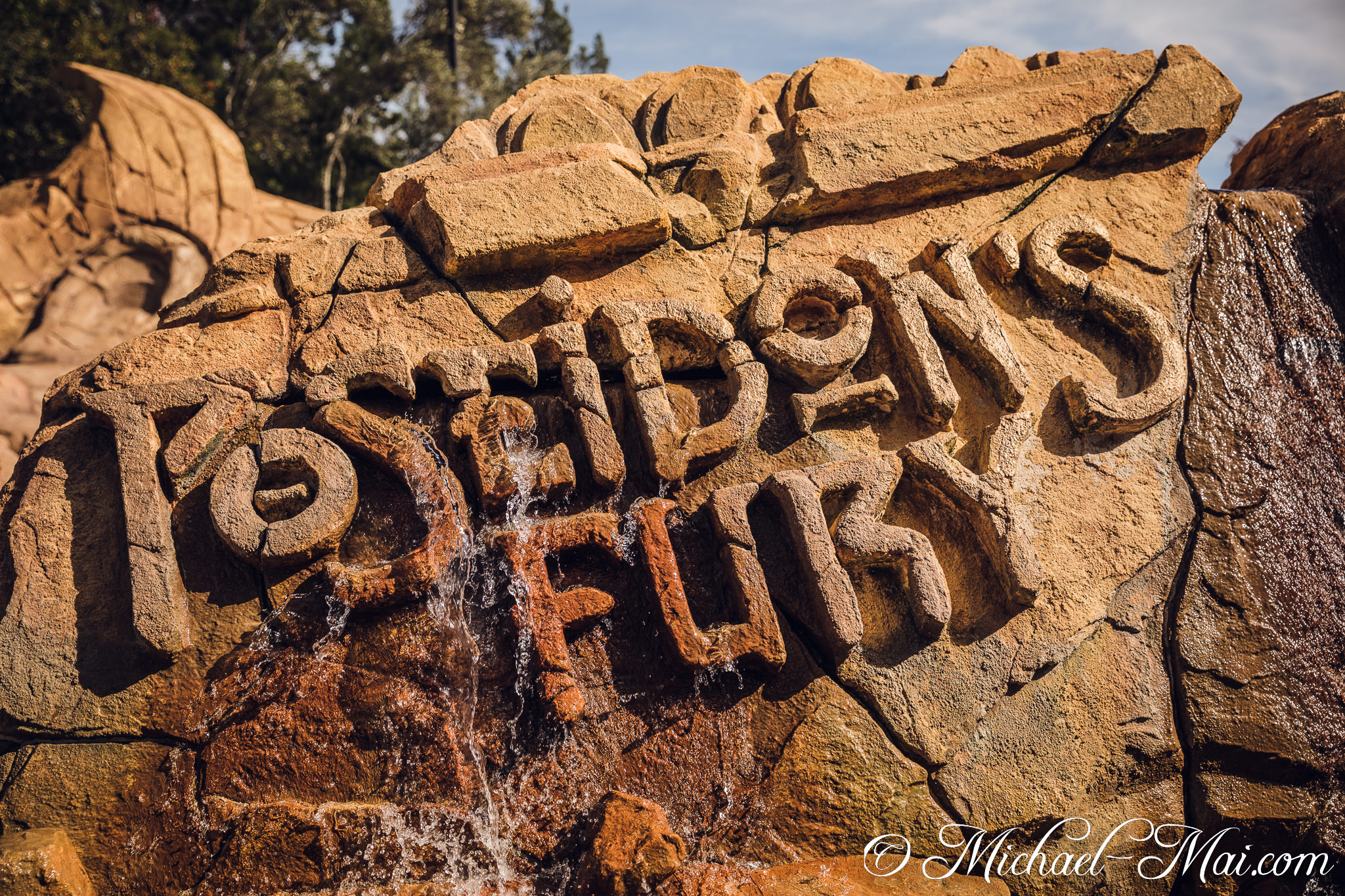Carved rock details gleam, illuminated by flowing water, revealing a god's fury. | Orlando, Florida, United States