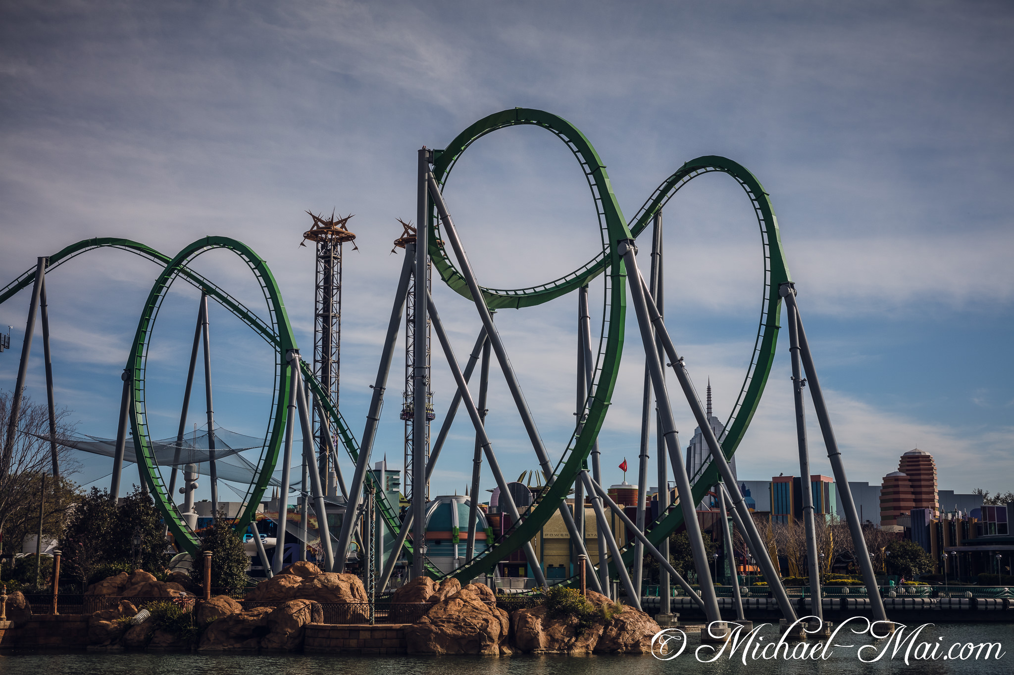 Dynamic green coaster track soars with thrilling inversions over a scenic lagoon. | Orlando, Florida, United States